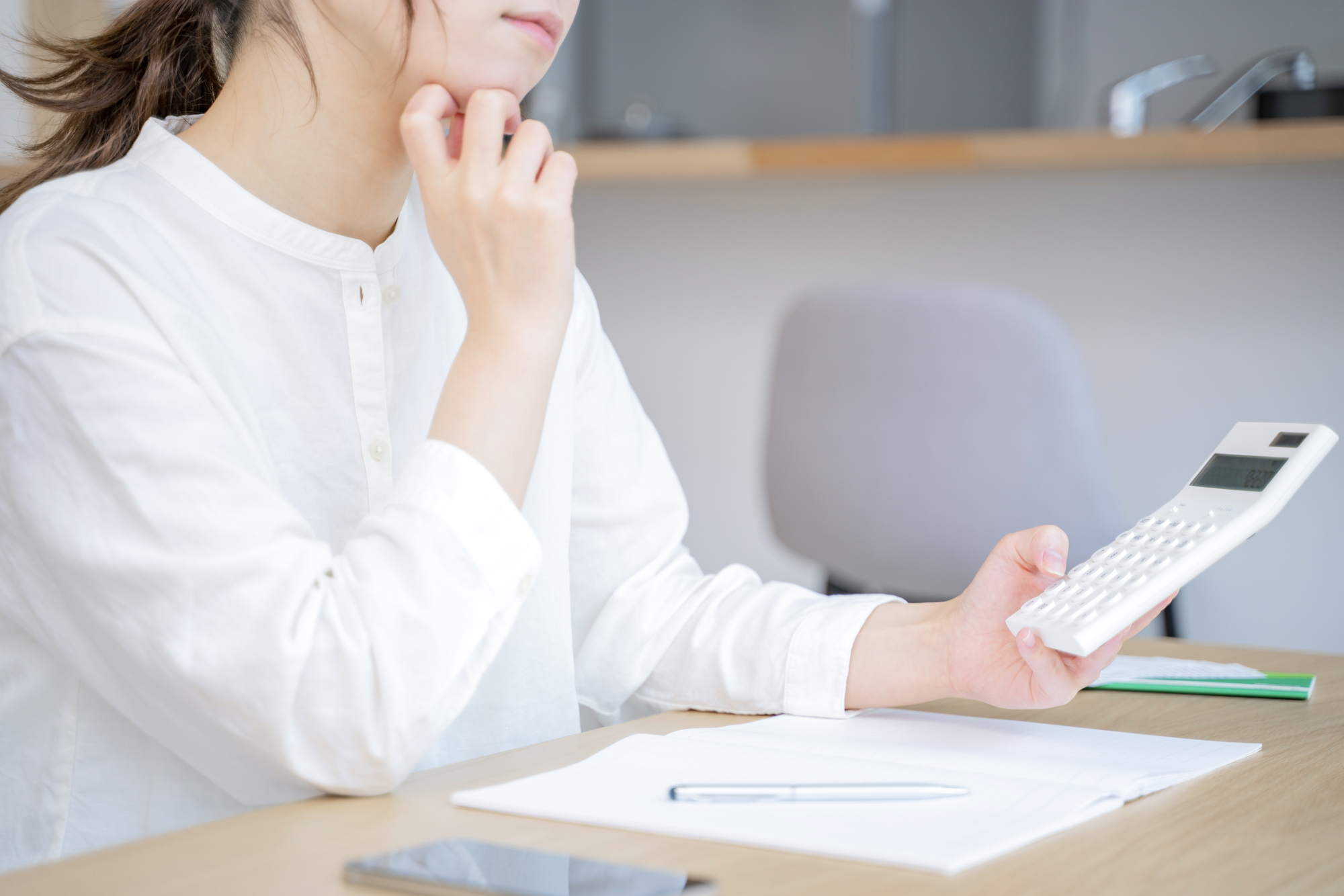 女性と電卓で支払いを検討しているイメージ画像